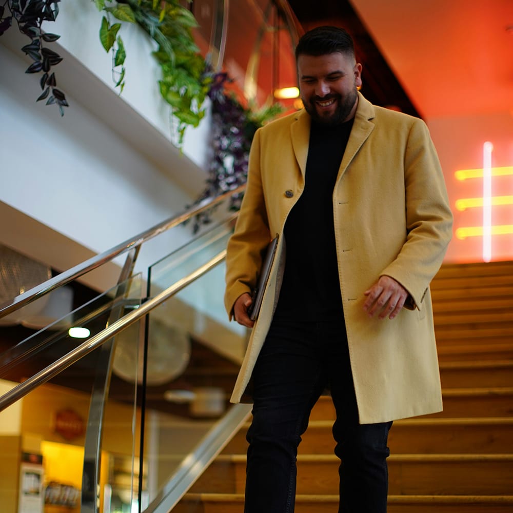carlos-gil-j9JDJlQagd0-unsplash man walking down stairs